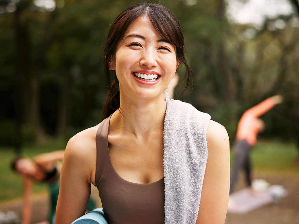 Smiling woman post-LASIK enhancement enjoys outdoor yoga, illustrating “can I have LASIK twice