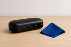 how to remove scratches from glasses — hard eyeglass case and microfiber cloth on a table