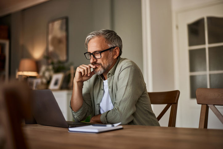 Man at a computer trying to calculate how much cataract surgery costs.