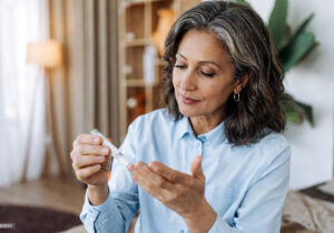 Diabetes can be one of the causes of blurry vision, woman self testing her blood sugar, with Vantage Eye Center.