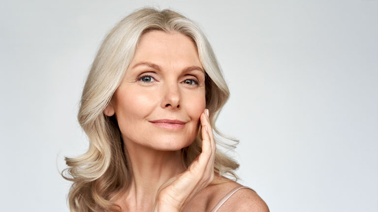 An older woman excited about her filler results.