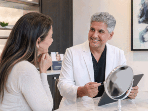 Dr. Mazi Bidar discussing dermal fillers with a patient during a cosmetic consultation for Botox and blepharoplasty in Monterey at Vantage Eye Center.